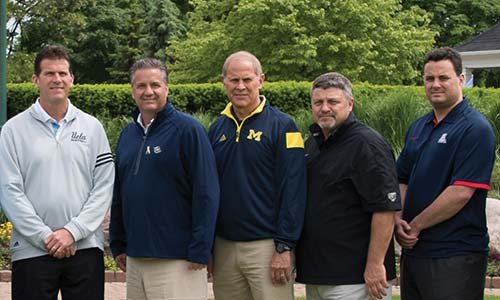 Oakland University head men's basketball coach Greg Kampe poses on a golf course with other athletic leaders and Michigan basketball coaches.