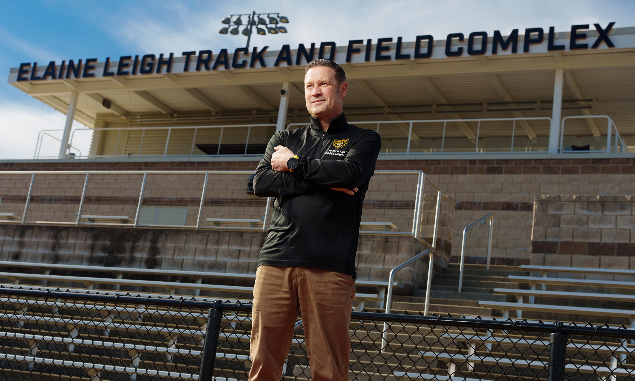 A man standing with the "Elaine Leigh Track and Field Complex" sign behind him