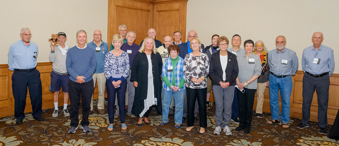 A group of older Oakland University alumni, posing for a group photo.