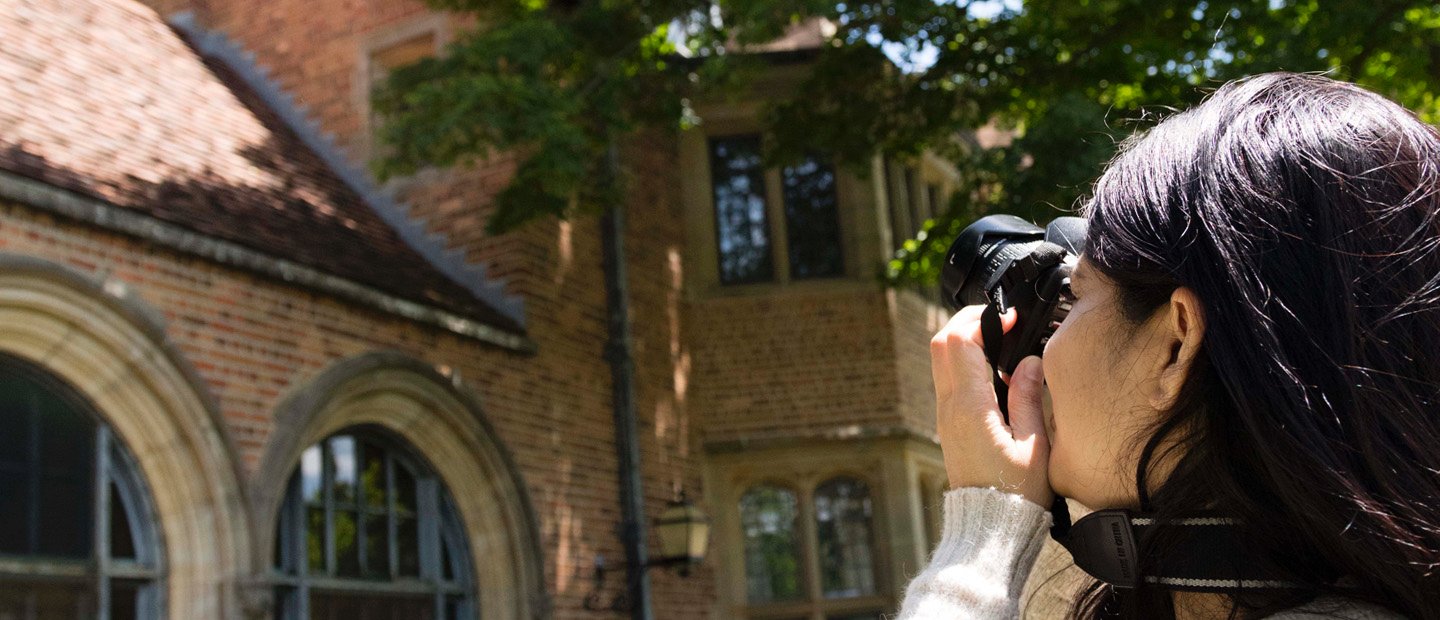 woman taking a photo of the exterior of a brick building