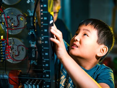 Young child interacting with a circuit board hands-on