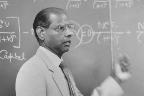 Dr. Sid Mittra standing in front of a chalkboard with equations written on it.