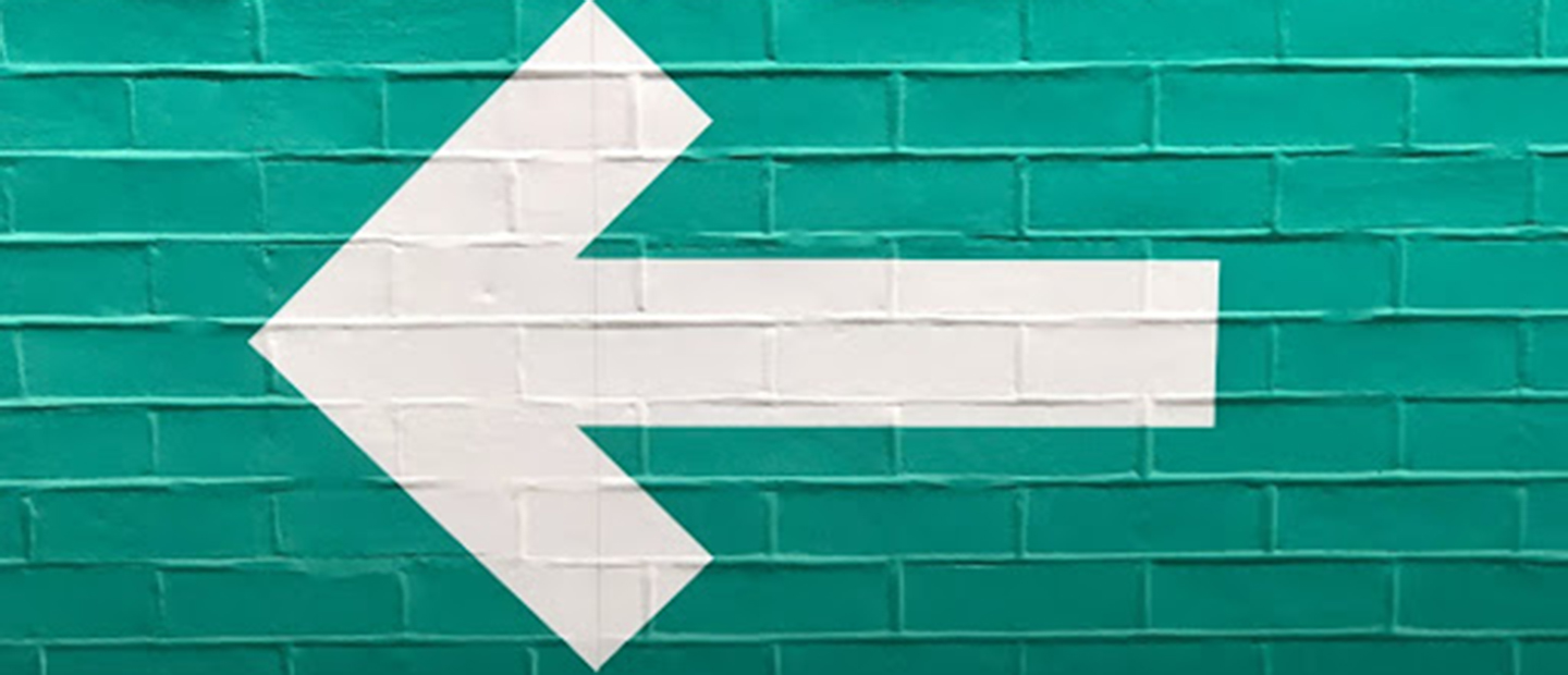 white arrow on green wall