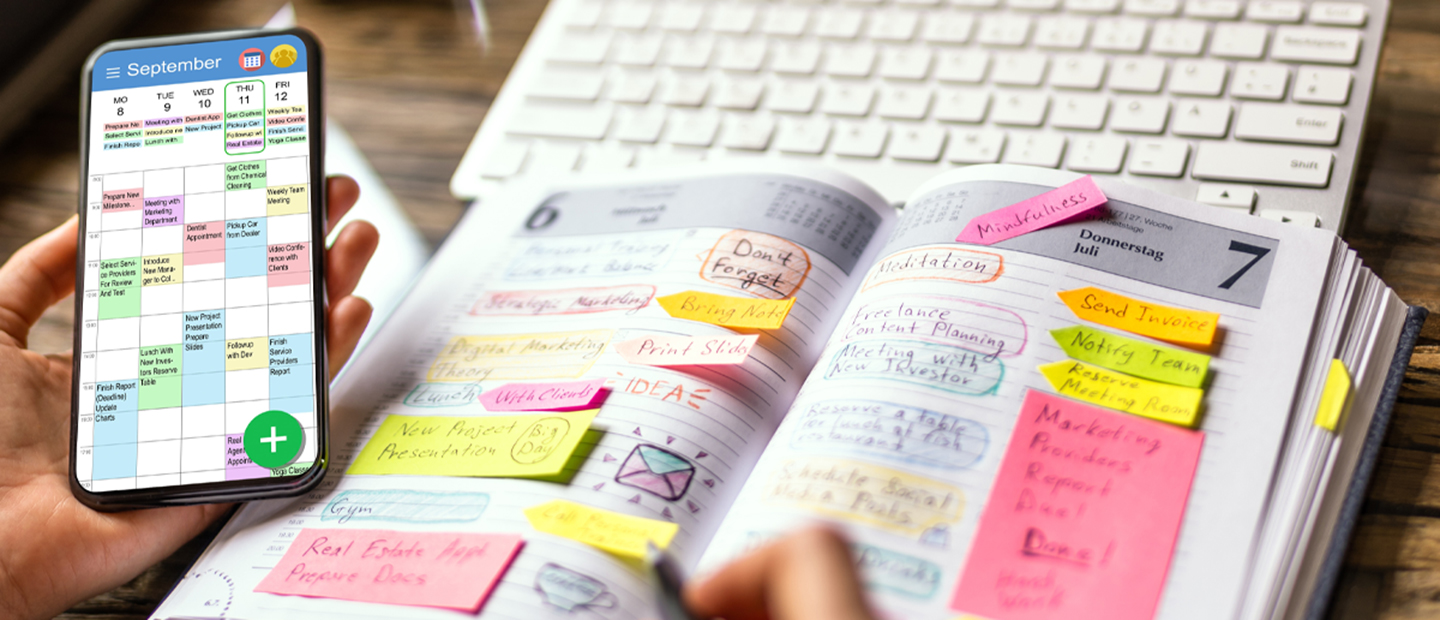 A person with a notebook calendar open as well as one on their phone.