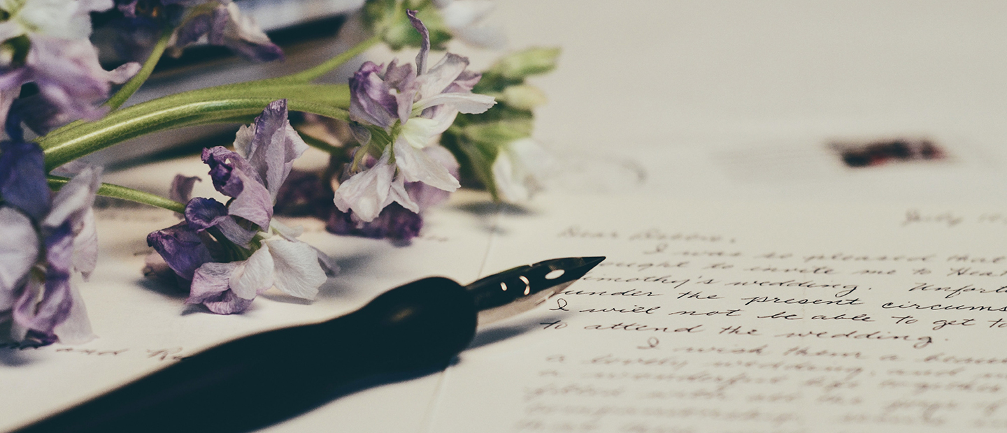 Fountain pen and purple flowers on paper