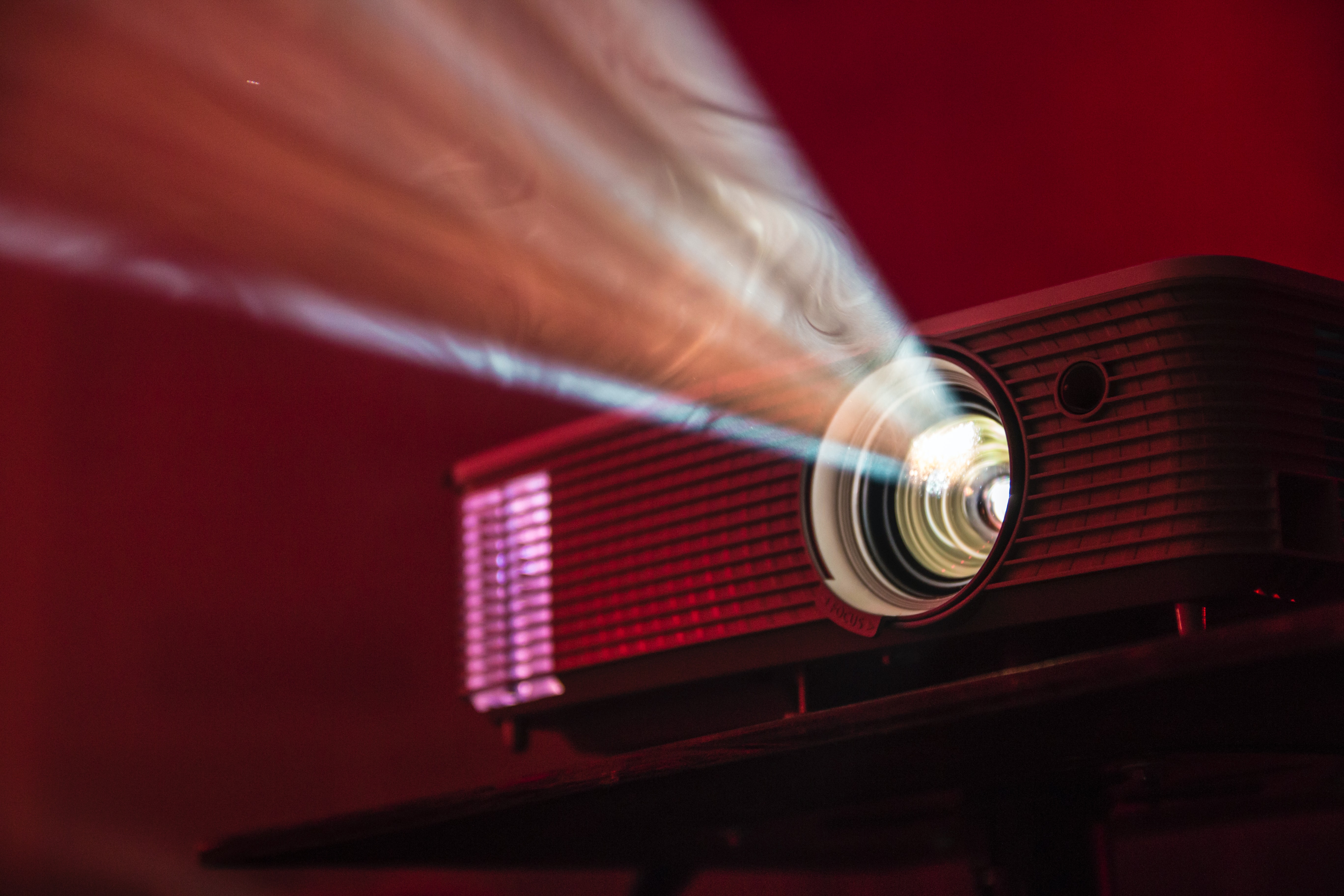 small projector lit up in a dark space