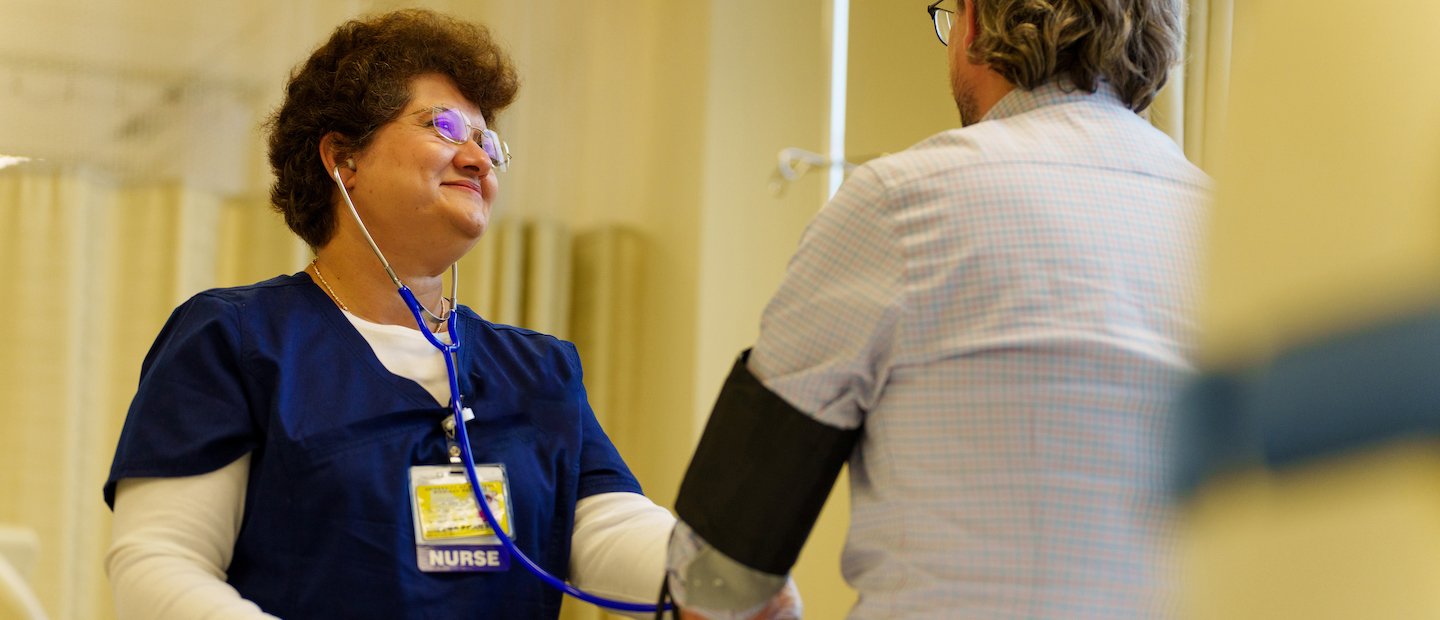 Success Stories A nurse taking a man's blood pressure.