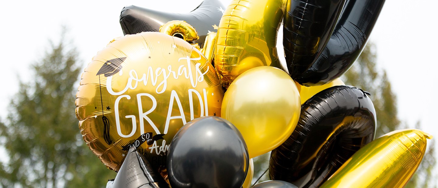 A bundle of gold and black balloons of different shapes and sizes.