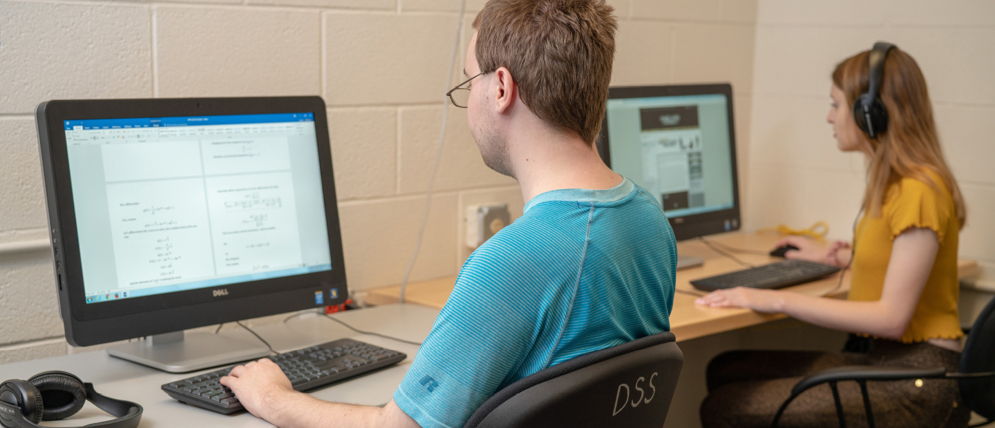 Student Resources two young adults seated at desk with computers and headphones