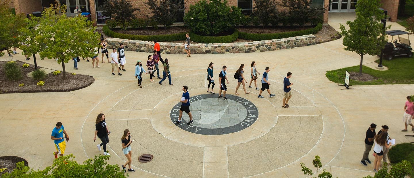 Students in a group walking across Oakland University's campus outdoors
