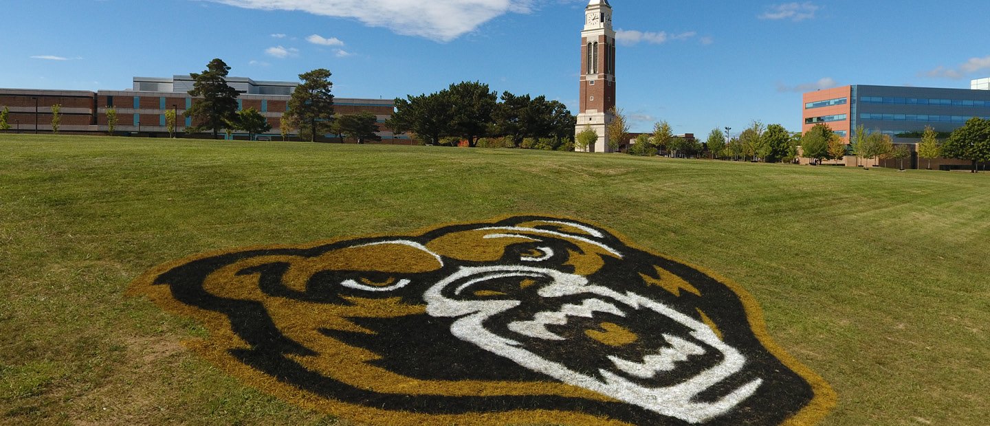 grizz head logo painted on the grass outside of the athletics building