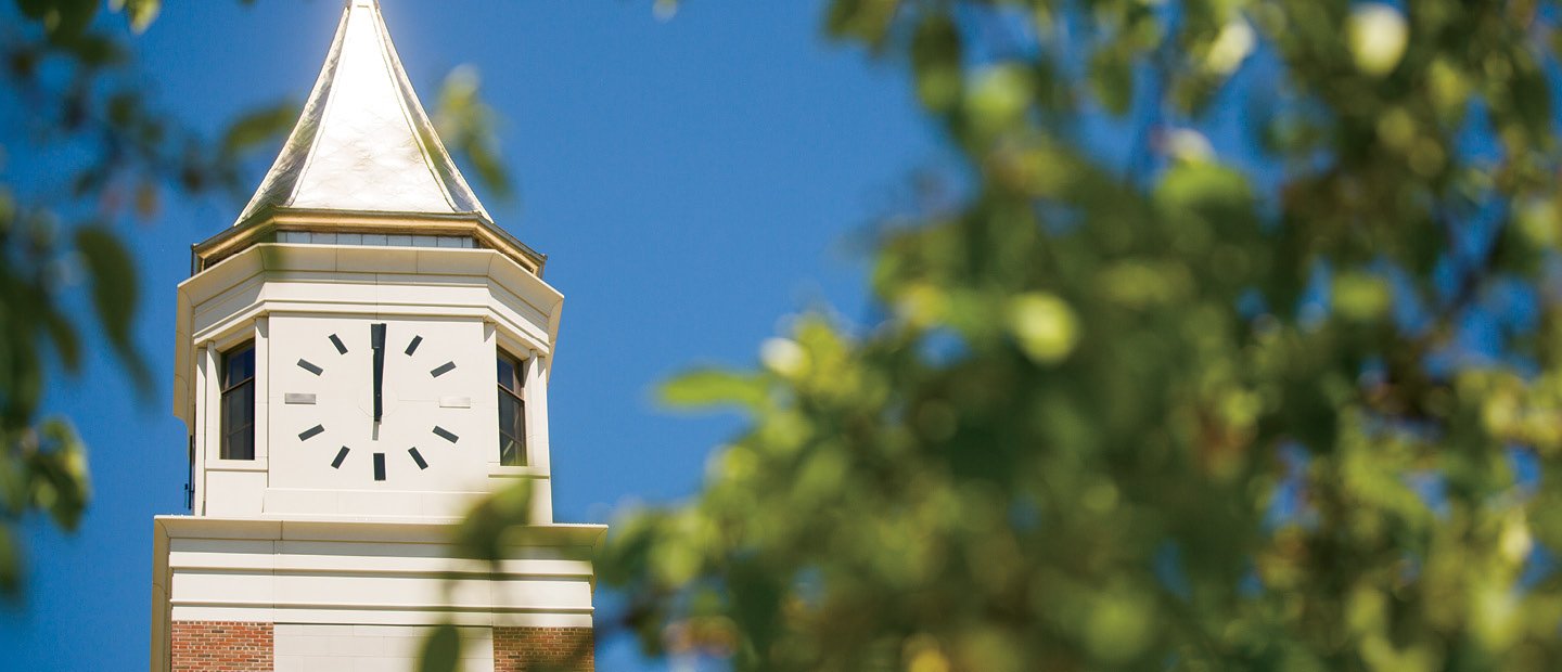 the top of Elliott Tower in focus with blurry tree branches in front