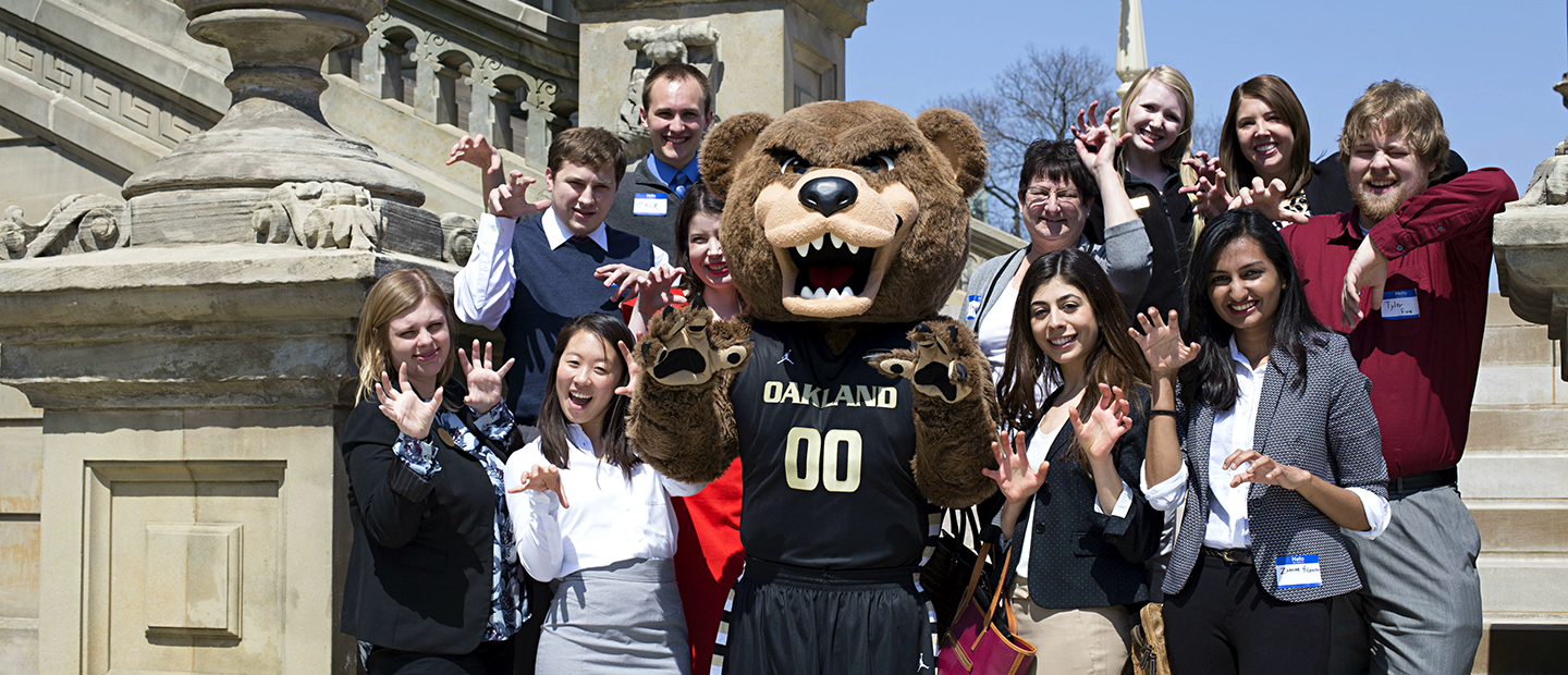 Grassroots Grizzlies A group of students posing for a photo with the Grizz bear mascot.