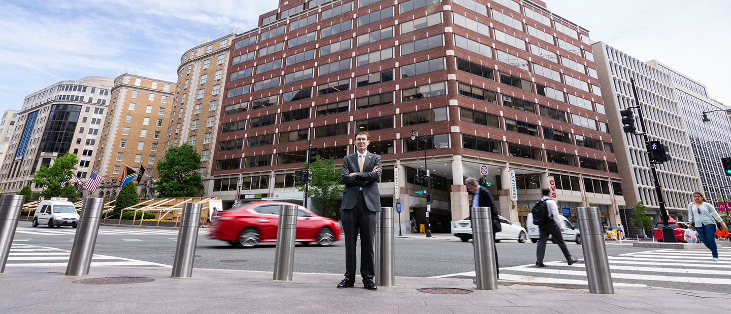 image of Lee Casey standing in downtown Washington D.C. on a sidewalk with traffic behind him