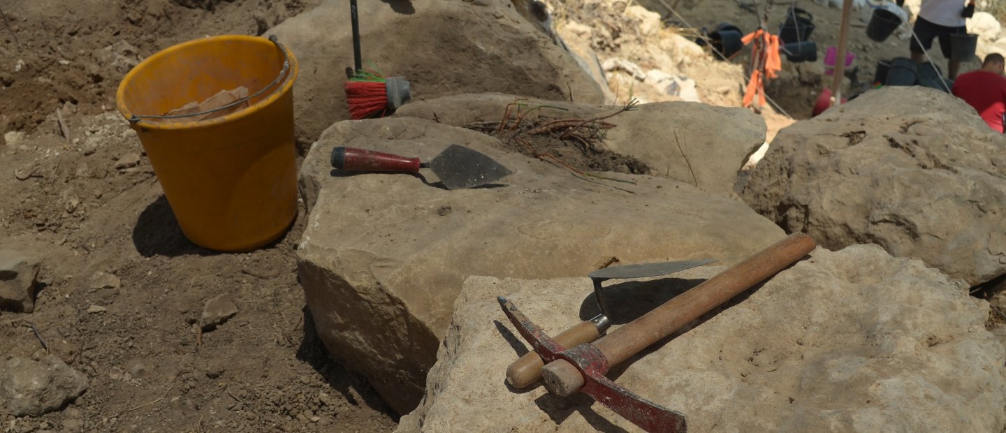 Archeology in Israel Tools sitting on rocks at an archaeological dig site.