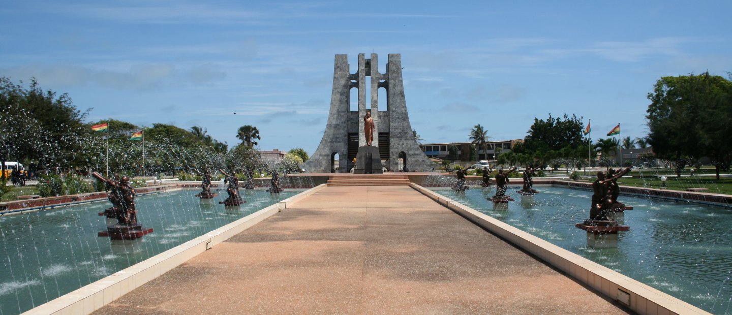A fountain in Ghana with sculptures and a path in the middle.