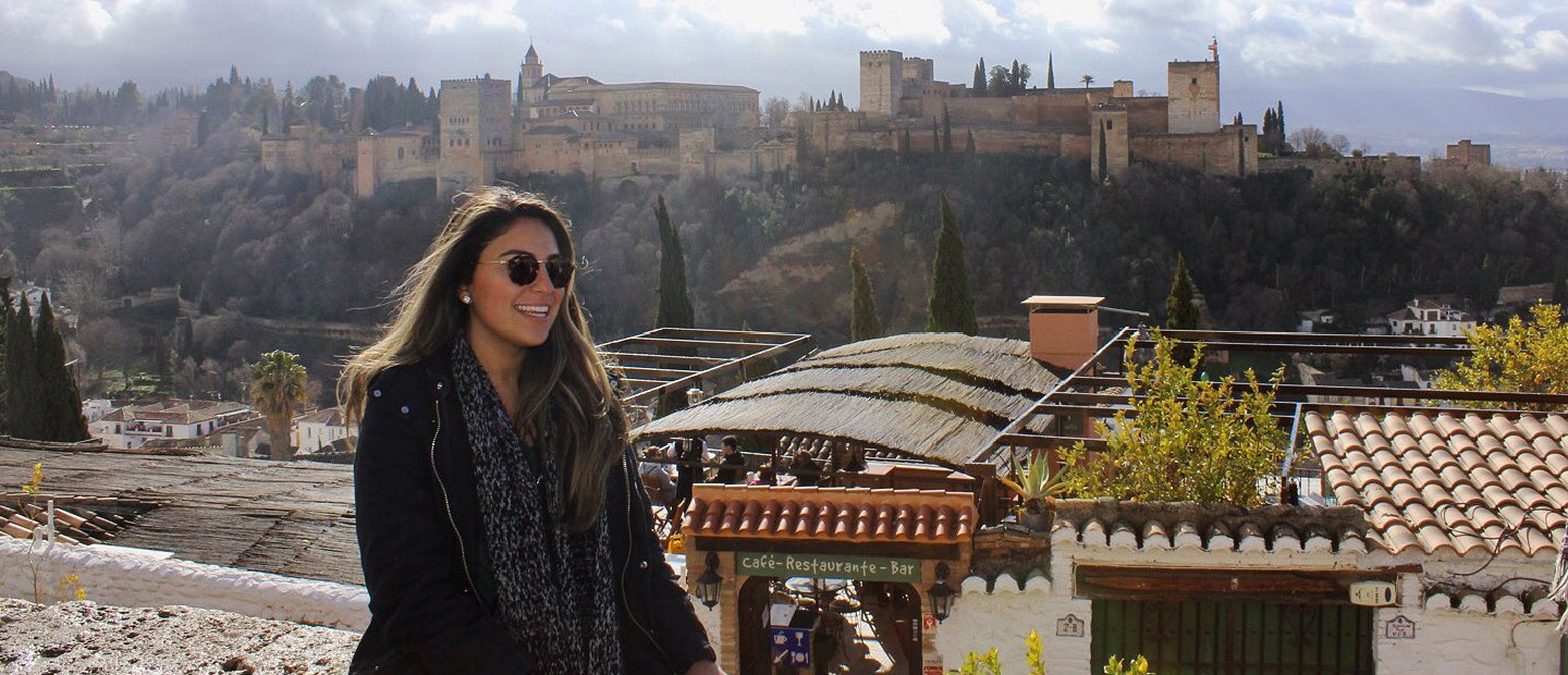 A woman posing for a photo with a city skyline in the background.