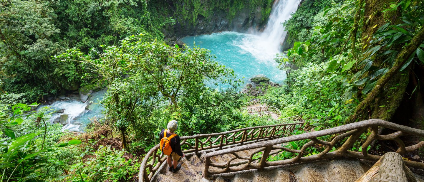 A person on an overlook at a waterfall in Costa Rica.