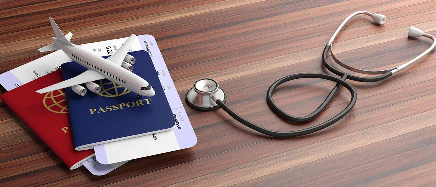 Health and Safety Two passports, a small model of an airplane and a stethoscope on a table.