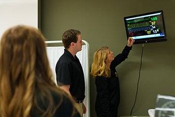 Three people reading vitals on a screen