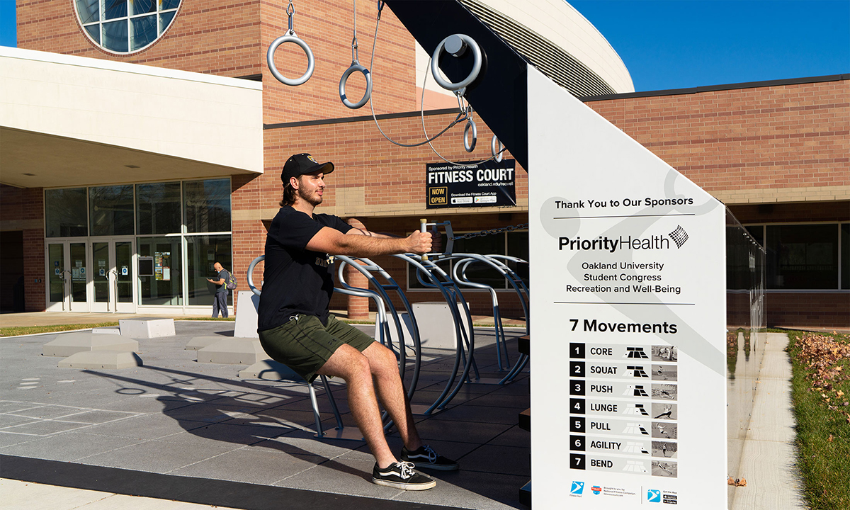 A man using Oakland University's Priority Health Fitness Court