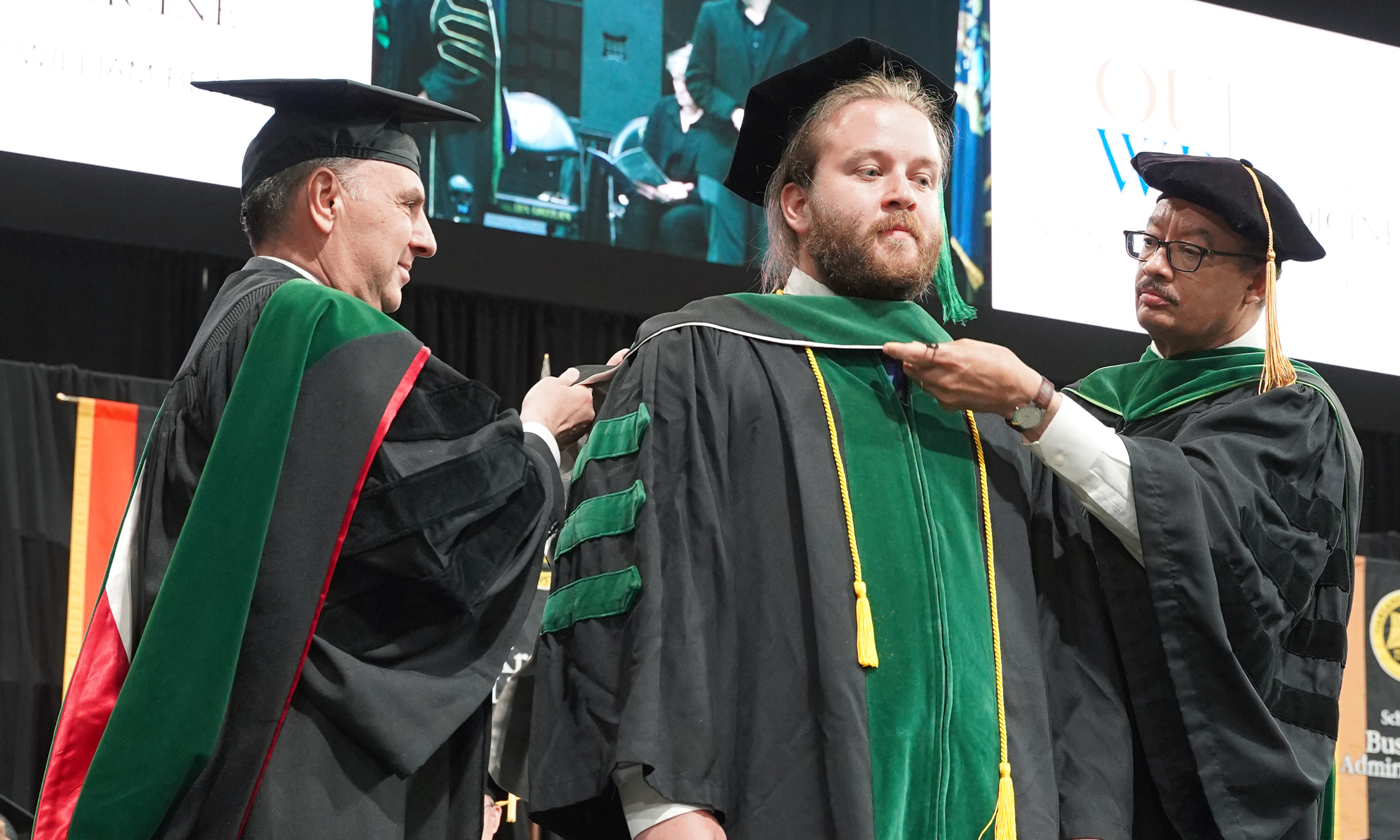 An image of James Blumline being hooded at commencement