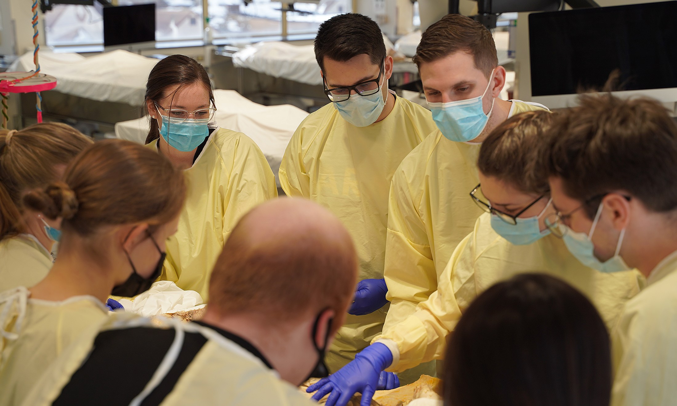 An image of a group of students in OUWB's anatomy lab.