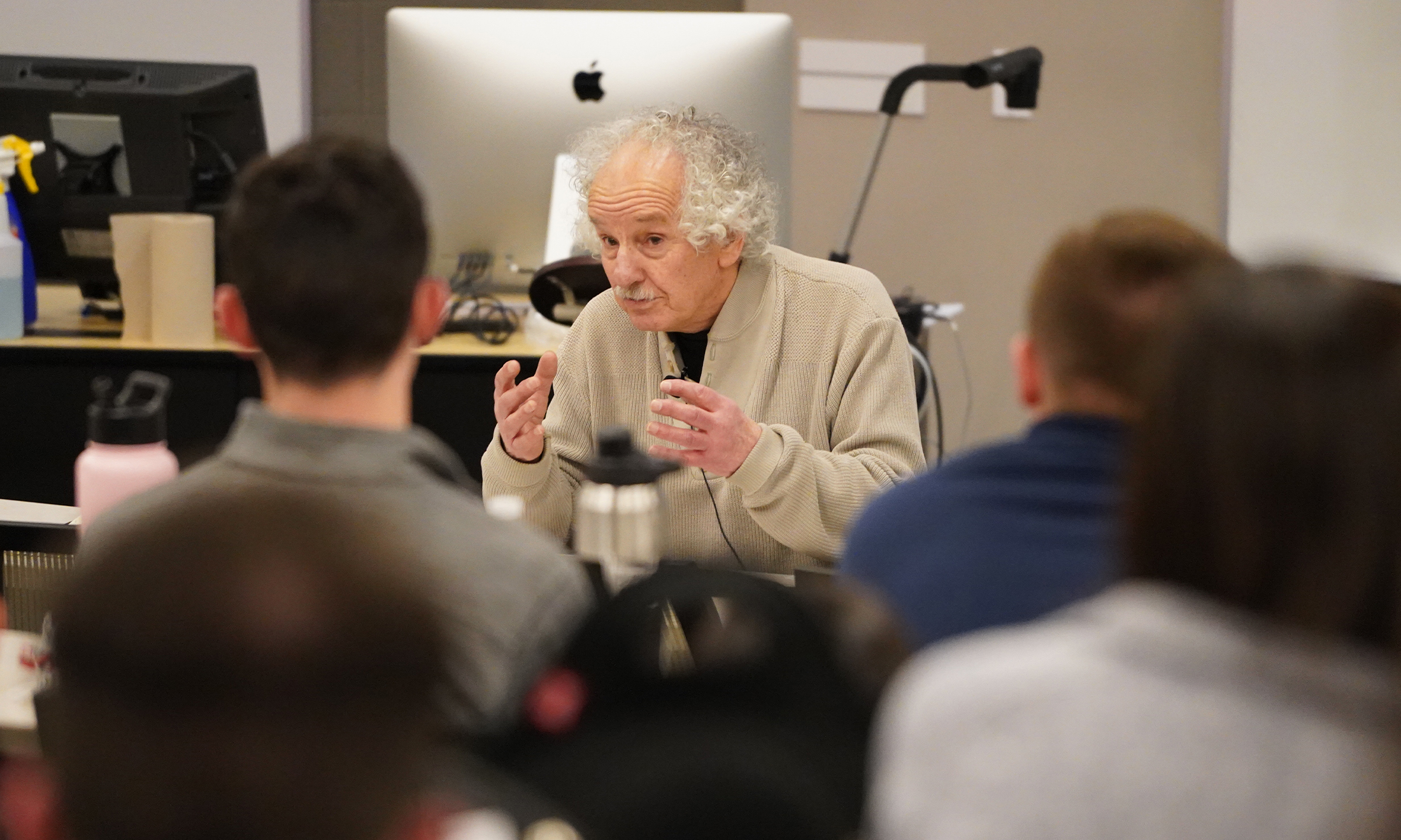 An image of a Holocaust survivor talking to students