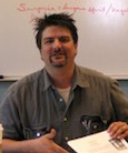 Marshall Kitchens seated at a desk in a classroom.