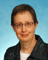 Headshot of Dr. Barbara Ducatman wearing a blazer in front of a blue background