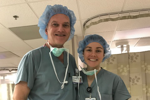 Mark and Sarah Dykowski in scrubs and hair nets in a hospital