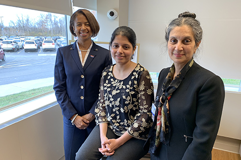 OUWB and UDM collaborators three women in professional attire posting in a room with a window