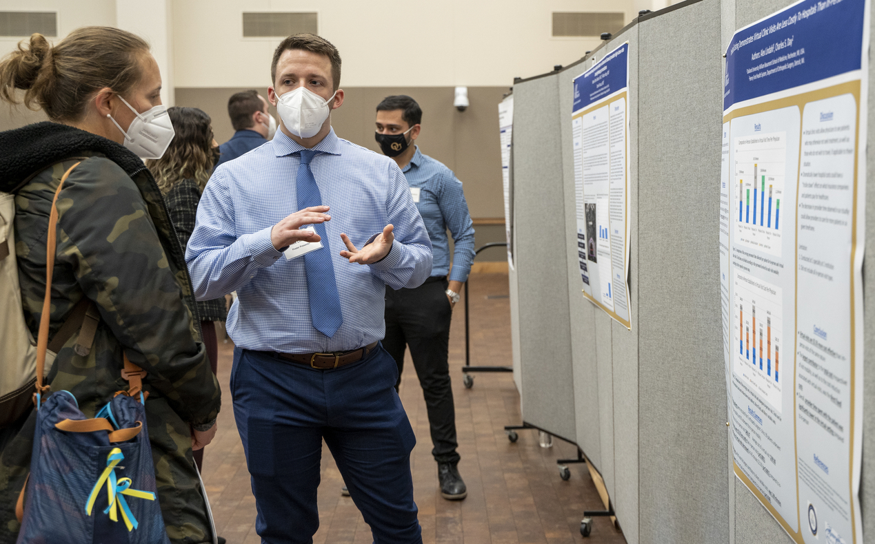 An OUWB student talking about his research poster. 