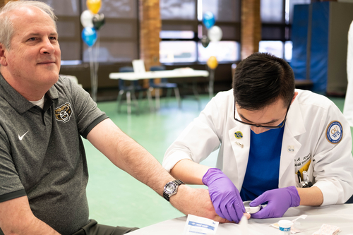 An image of Bob Noiva and student at a community health fair