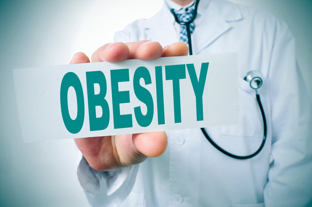 110723 ObesityProject1 An image of a physician holding a sign that says obesity