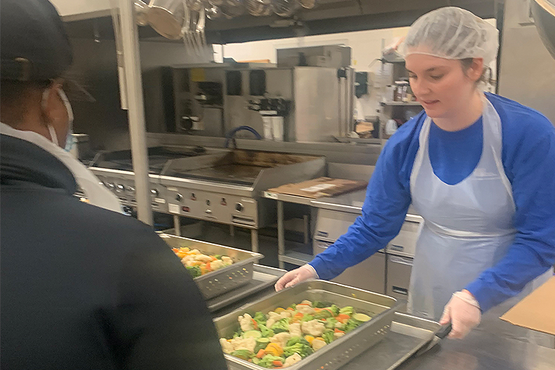 An image of an OUWB student working in a kitchen