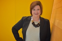 woman in a black jacket and white shirt smiling at the camera