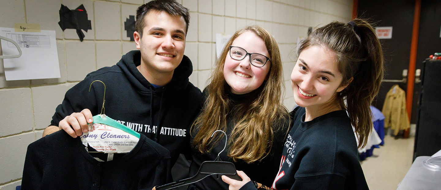 image of three young people backstage, smiling