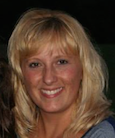 woman in a gray shirt smiling at the camera