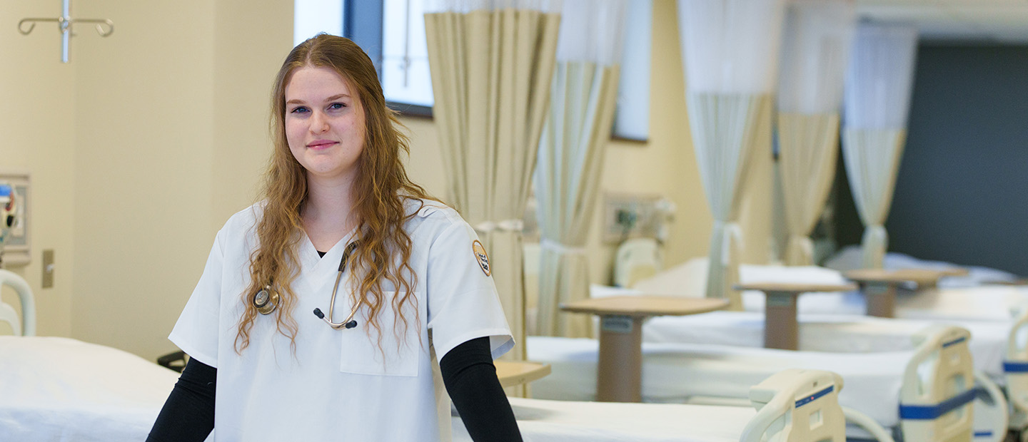 Basic BSN student near lab bed