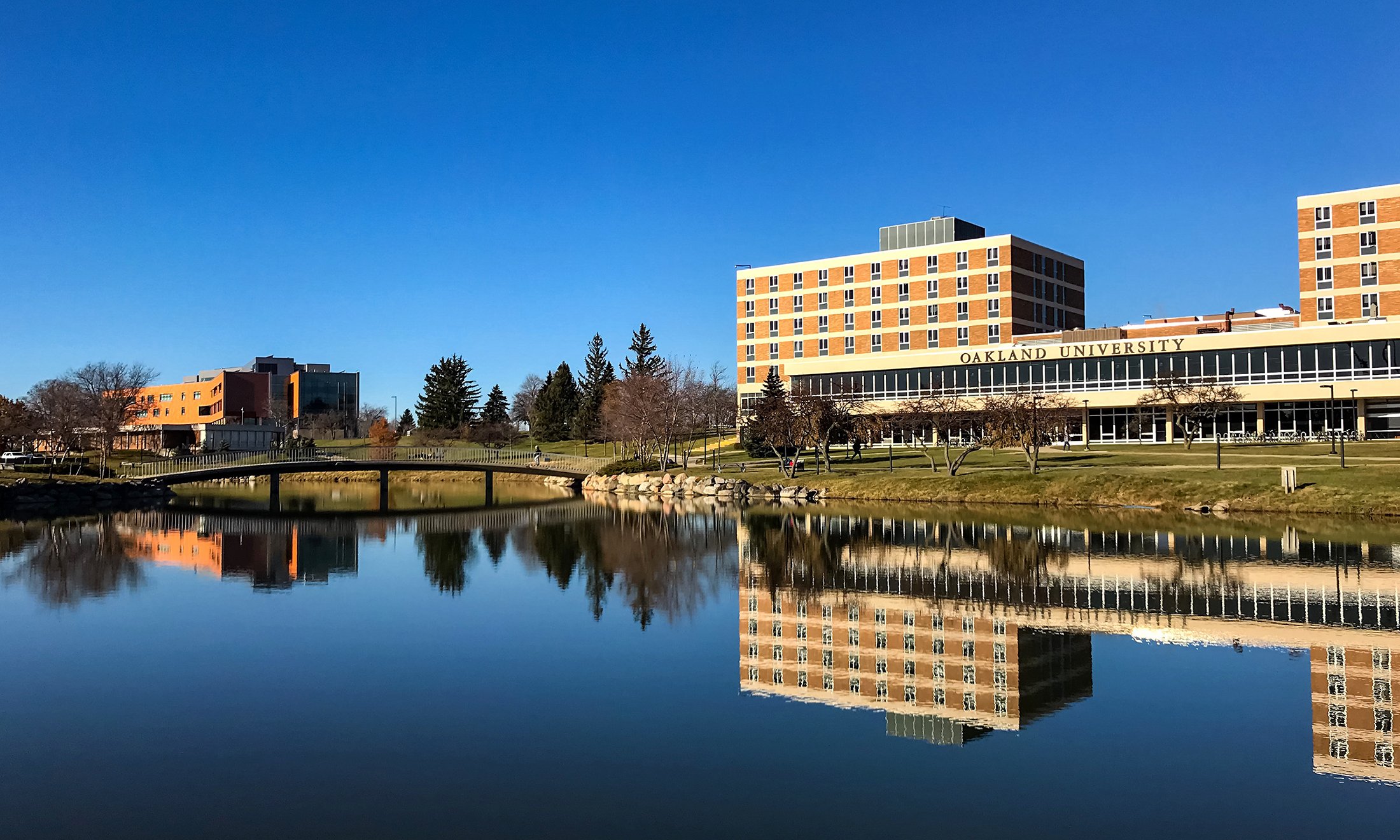 Color photo of Vandenberg Hall and Bear Lake with crystal clear blue sky and reflection of buildings in water