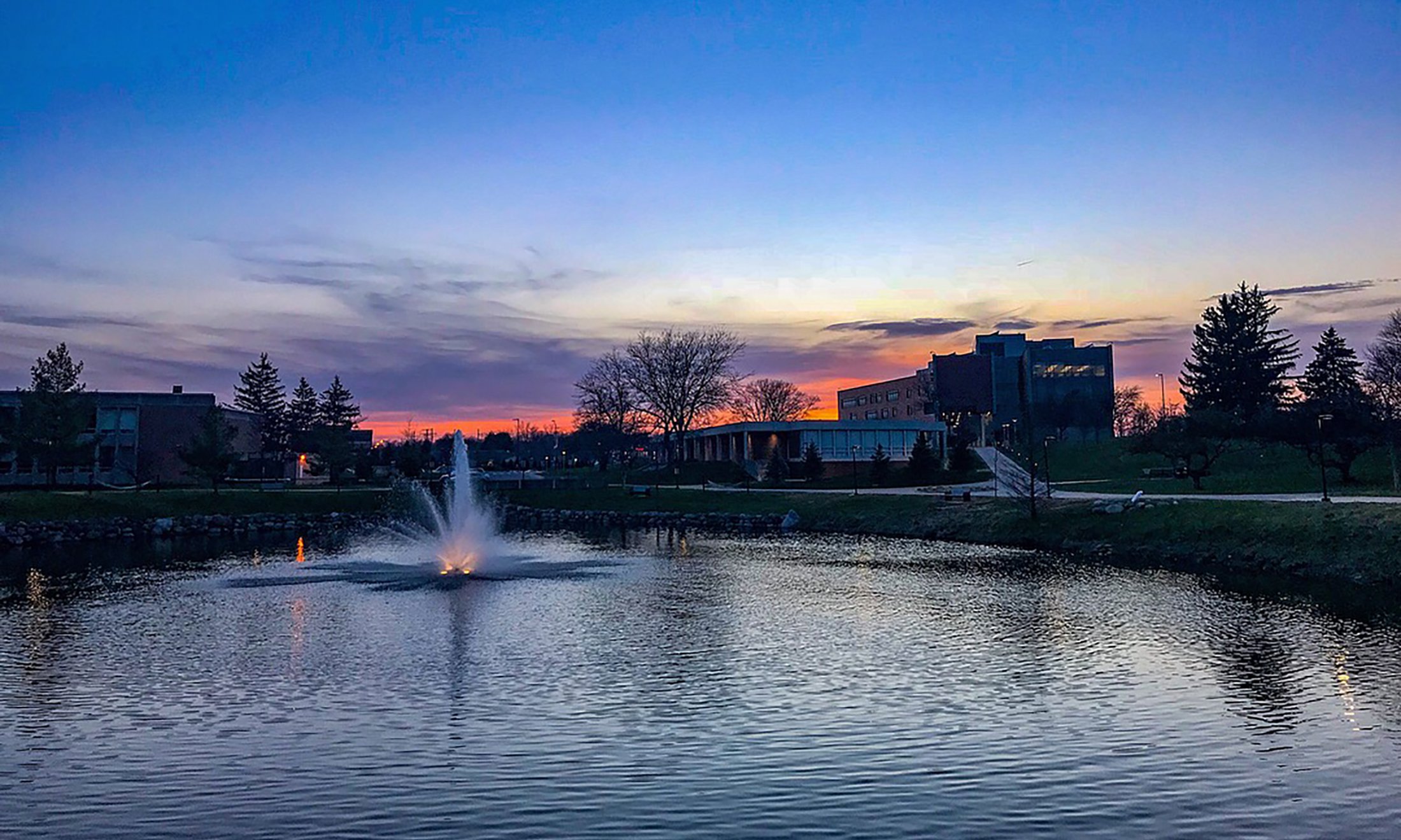 Sunset photo of bear lake fountain looking east toward human health building