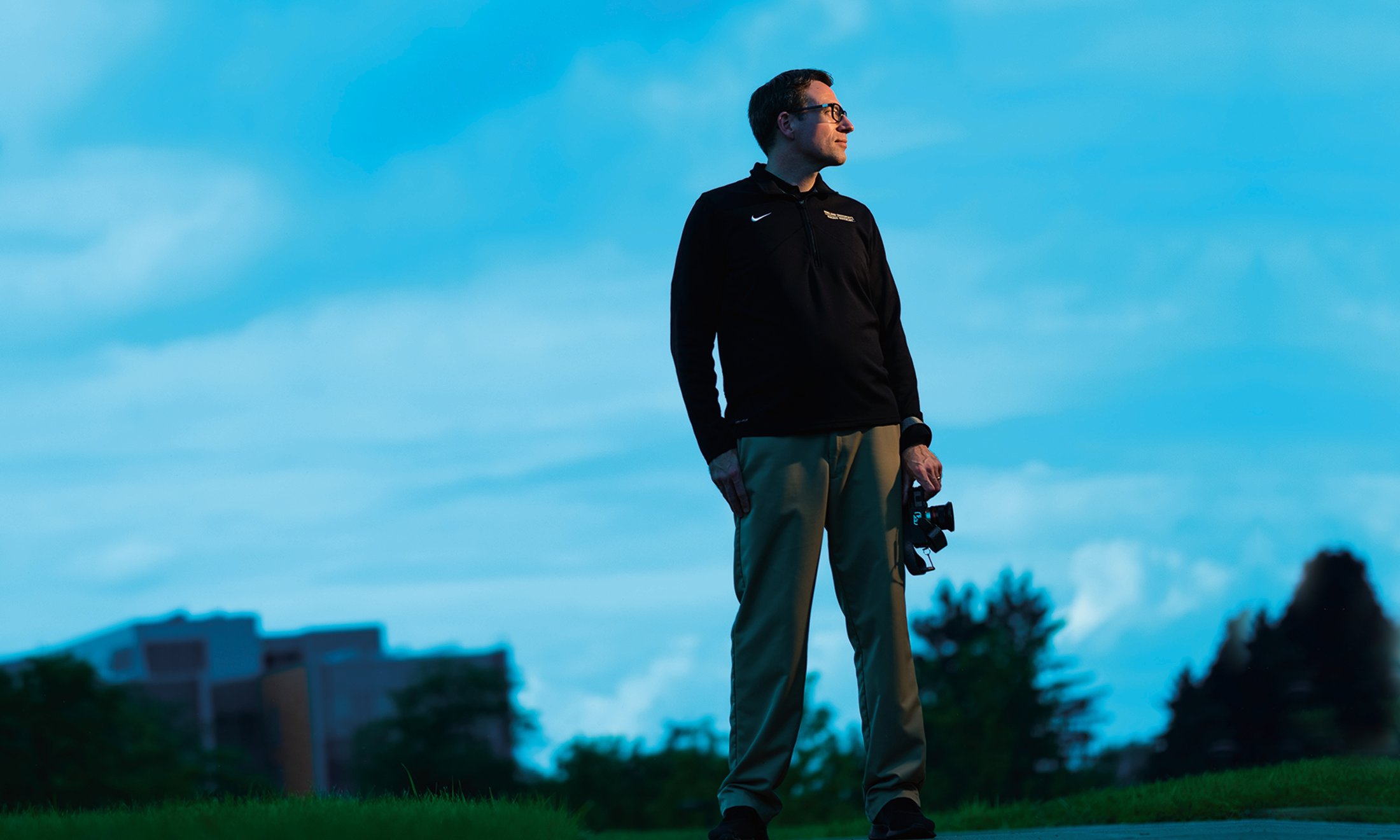 Staff member Matt Boltz standing on campus with a camera