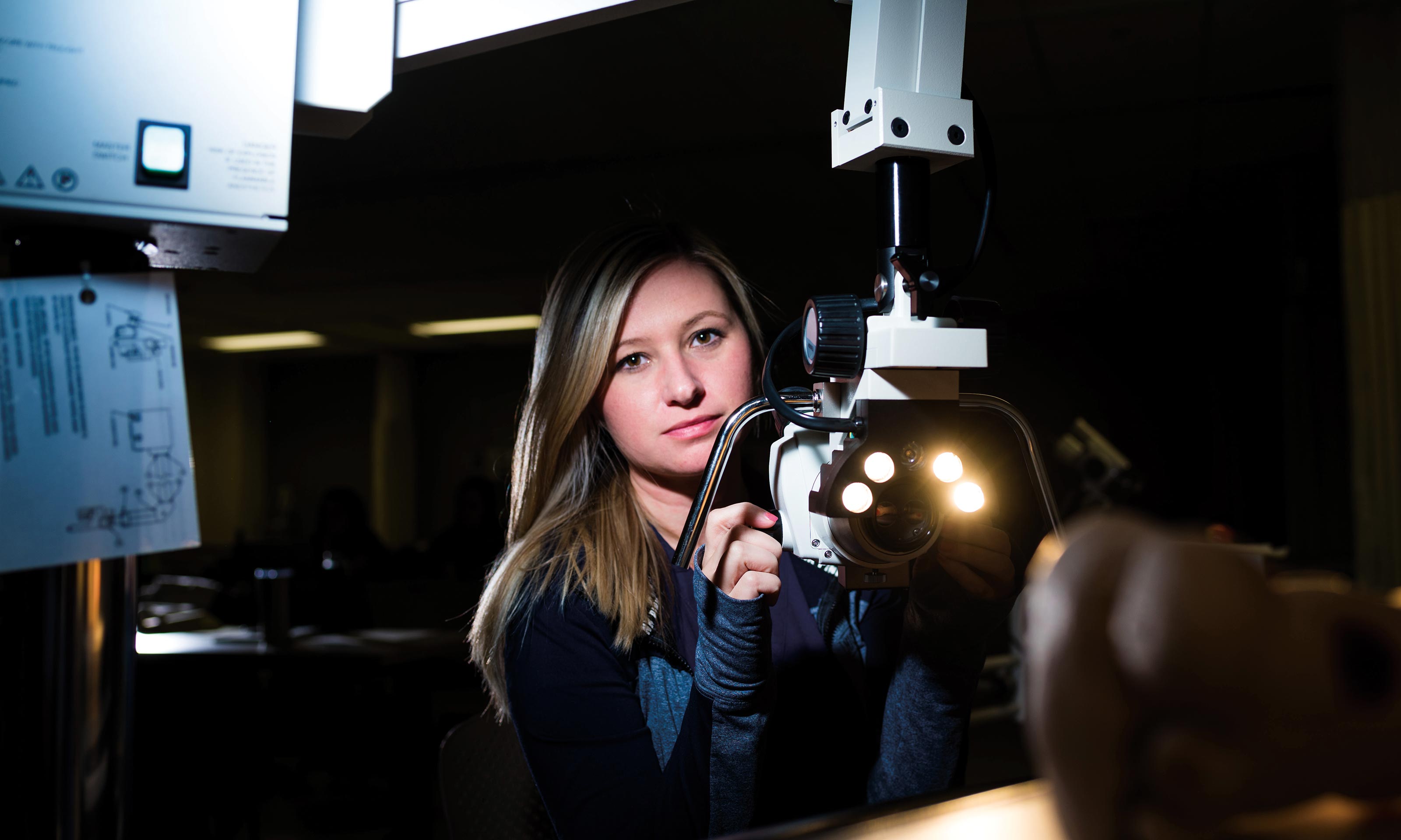 Forensic nursing student looks through a colposcope