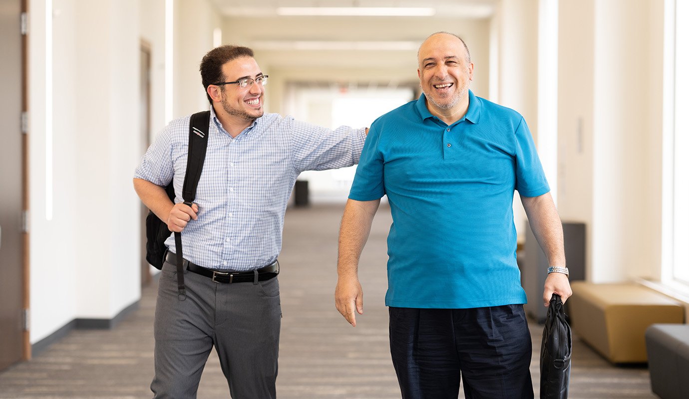 Two men walking down hallway