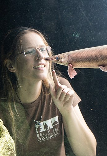 Woman looking at fish through tank