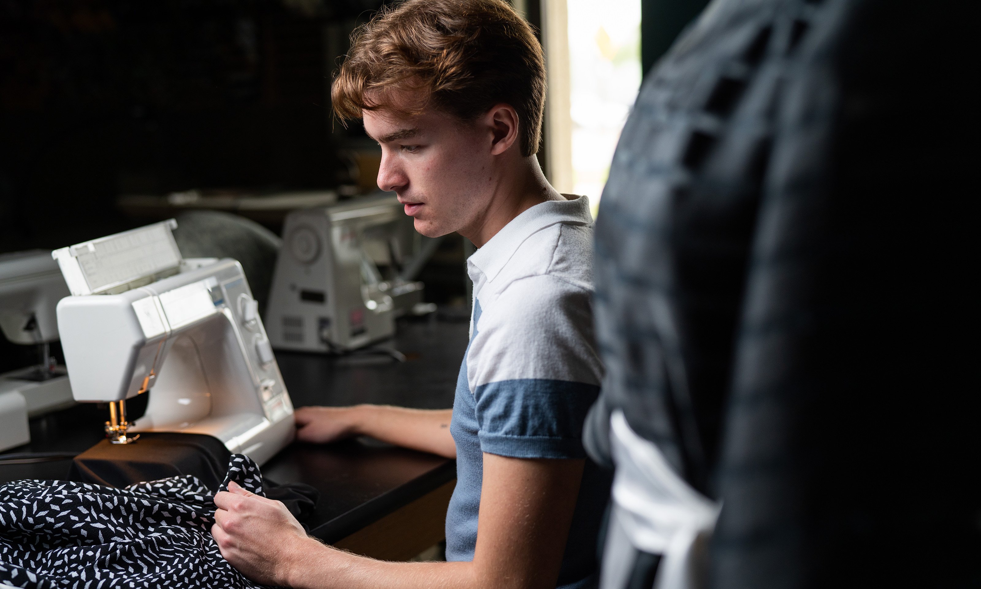 Student sitting at sewing machine