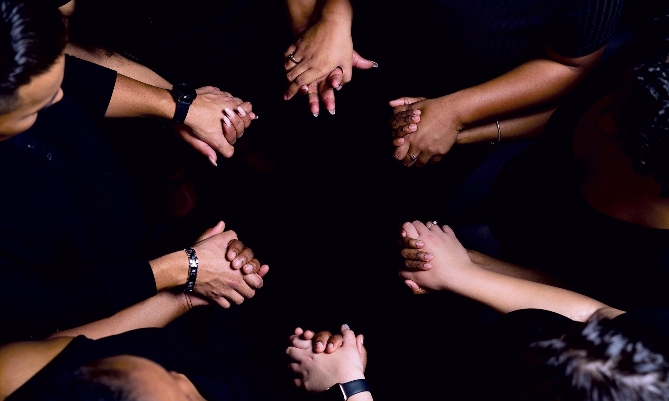 Overhead shot of people holding hands creating a circle.