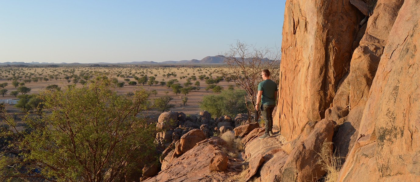 Man standing on cliff overlooking desert vista