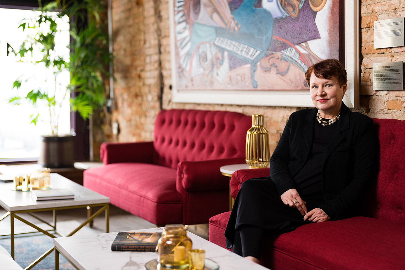 A woman sitting in a red couch in a lounge